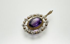 An Edwardian yellow metal pendant set with an oval facet-cut amethyst (approxiamely 3.5ct) within