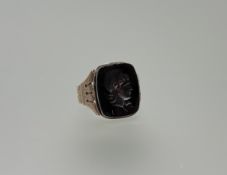 A rose metal seal ring set with a hematite intaglio with incised Roman soldier in profile in foil