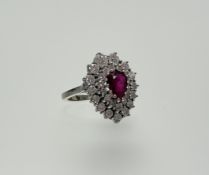 An 18ct white gold ring set enhanced pear-shaped ruby enclosed within two outer bands of brilliant