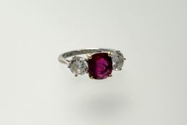 A platinum and yellow 18ct gold ring set enhanced cushion cut ruby approximately 3ct flanked by a