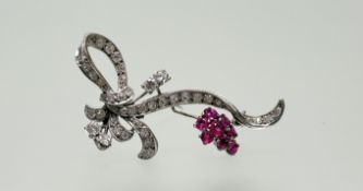 An 18ct white gold ruby and diamond ribbon knot spray brooch set seventeen rubies, approximately 0.