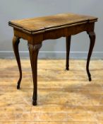 A Georgian mahogany foldover tea table with scalloped edge and frieze on slim curved scroll supports