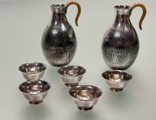 A cased Japanese silver Sake set, early 20th century, the pair of jugs with textured 