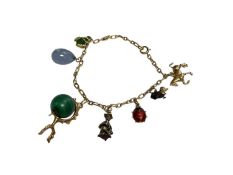 Yellow metal charm bracelet with seven various novelty charms