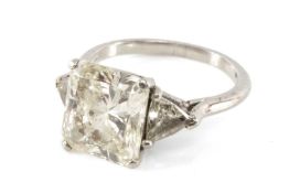 WHITE METAL DIAMOND RADIANT CUT RING, flanked by two trillion cut diamond shoulders (5mms side