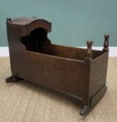 ANTIQUE PANELLED OAK CRIB, with hood, turned finials on bowed rockers, 68 (h) x 92 (w) x 54cms (d)