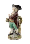 EARLY 19TH C. PEARLWARE 'HEARTY GOOD FELLOW' TOBY JUG, standing with twisted body, holding jug of