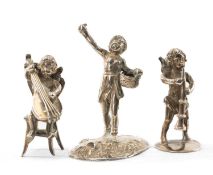 THREE CONTINENTAL SILVER FIGURINES, comprising child with basket, seated cupid with cello, and cupid