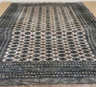 TEKKE-BOKHARA STYLE MAIN CARPET, beige field of repeating guls, multiple guards and floral