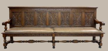 LARGE VICTORIAN CARVED OAK SETTLE, ensuite to the previous lot, with seven foliate carved back