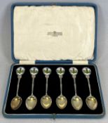 CASED SET OF SIX GEORGE V SILVER TEASPOONS, handles enamelled with golfing figures, gilded bowls,