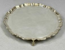 GEORGE V CIRCULAR SILVER SALVER with shaped moulded rim, on four scroll feet, Hawksworth, Eyre & Co.