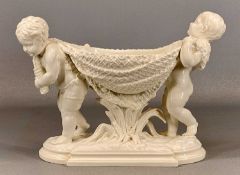 WILLIAM BROWNFIELD & SONS WHITE GLAZED FLOWER BOWL, formed as two cherubs carrying a fishing net, on