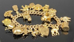 9CT GOLD CHARM BRACELET with 17 charms, heart shaped padlock, and safety chain, 46gms Provenance: