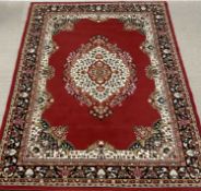 MODERN RUG, red ground with multi-border and central motif, 241 x 323cms Provenance: private