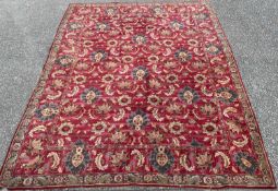 A LARGE WOOLLEN CARPET, red ground with wide border and all over floral pattern, 360 x 292cms