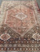 EASTERN WOOLLEN RUG, red/rust ground with multi-pattern border, diamond and hexagonal motifs, 282