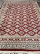 PERSIAN WOOLLEN RUG of red and cream ground, multi-border with repeating diamond pattern throughout,