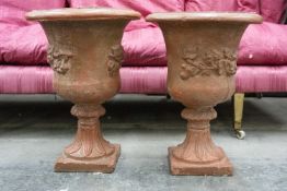 PAIR OF PAINTED TERRACOTTA URNS with moulded decoration and leaf moulded socle bases, 57cms (h) (