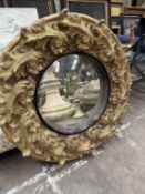 LARGE CIRCULAR GILT GESSO MIRROR, circular central mirror. deep scroll and foliate border, 112cms (