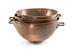 THREE GRADUATED COPPER COOKING BOWLS, rounded bottoms, with riveted copper handles, largest 56cms (