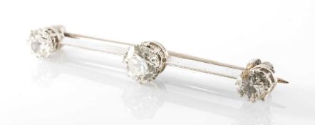 WHITE METAL THREE STONE DIAMOND BAR BROOCH, the three claw set round brilliant cut diamonds