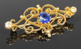 15CT GOLD SCROLLED OPENWORK BROOCH, set with central sapphire and two small diamonds, 40 x 20mms,
