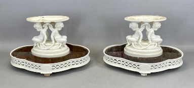 PAIR OF WHITE GLAZED PORCELAIN CENTREPIECES, 19th century, each having twin figures of putti
