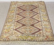 EASTERN WOOLLEN RUG, multi-coloured and bordered with central repeating diamond/zigzag pattern,