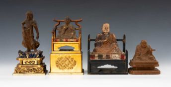 FOUR JAPANESE WOOD ZUSHI FIGURES, including three seated Buddhist monks on cushioned daises, and a