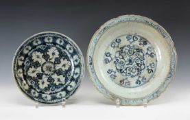 TWO CHINESE PROVINCIAL BLUE & WHITE SAUCER DISHES, 17th C., larger painted with scrolling tendrils