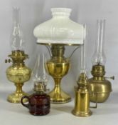 FIVE VARIOUS OIL LAMPS, including embossed brass with twin burners, moulded red glass, and three