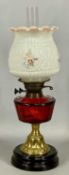 LATE 19TH CENTURY OIL LAMP with black ceramic base, brass column, faceted red glass reservoir,