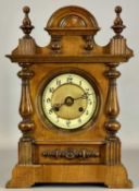 WALNUT CASED MANTEL CLOCK, with arched pediment, 8-day movement striking on a gong, 43cms (h)