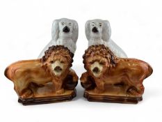 STAFFORDSHIRE ANIMALS, 19th century, pair of standing lions with glass eyes, front paws resting on