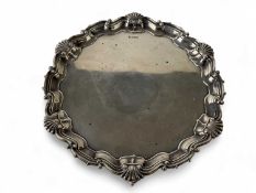 EDWARDIAN SILVER WAITER with raised shell border on three ball and claw feet, Mappin Brothers,