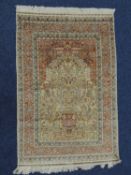 IRANIAN QUM SILK PRAYER RUG, the dark fawn mihrab centred with a floral vase, birds and deer, within