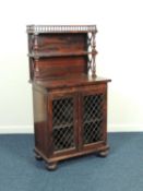 LATE REGENCY ROSEWOOD SIDE CABINET, c. 1820, with two bookshelf back, brass grill doors opening to