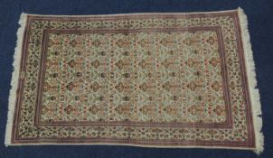 KIRMAN SILK RUG, late 20th Century, fawn field dispersed with flowering vases, birds and foliage, in