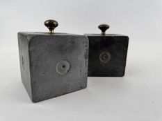 TWO WELSH FOLK ART SQUARE SLATE DOORSTOPS, carved with concentric circles, with brass knobs,