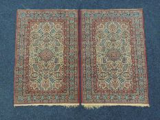 PAIR OF KASHAN WOOLLEN SMALL RUGS, Circa 1900-40, having a fawn field with red and blue