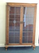 OAK BOOKCASE, c. 1930, leaded glazed double doors, bakelite drop handles, adjustable shelf lined
