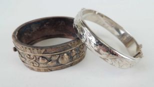 VICTORIAN OVAL SILVER HOLLOW BANGLE, hinged and with repousse decoration to one side, 65 x 55mms,