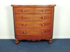 VICTORIAN MAHOGANY BOW FRONT CHEST OF DRAWERS, with turned handles and quarter twist columns, on