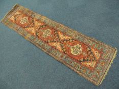 NORTH WEST PERSIAN WOOLLEN RUNNER, 20th Century, having three central pole medallions in red and