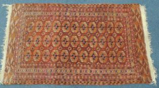 BOKHARA WOOLLEN RUG, early 20th Century, with madder field, 260 x 145cms Provenance: private