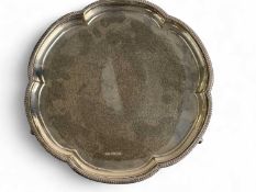 GEORGE VI CIRCULAR SILVER CARD TRAY, with shaped moulded gadrooned border, on three scrolled feet,