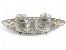 GEORGE V SILVER INK STAND, boat shape supporting two cut glass silver mounted inkwells, Barker