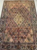 JOSHAGHAN WOOL CARPET, red ground with central diamond motif, 325cms x 220cms Provenance: private