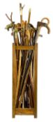 INTERESTING COLLECTION OF WALKING STICKS, some having brass animal head handles, contained in an oak